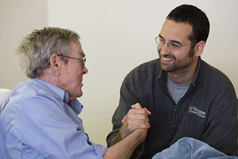 Mike Pereira (right), a University College student and Army veteran, visits with Navy veteran John “Mike” Kenny at the VA Medical Center in St. Louis. Pereira has worked with hospice patients since 2012.