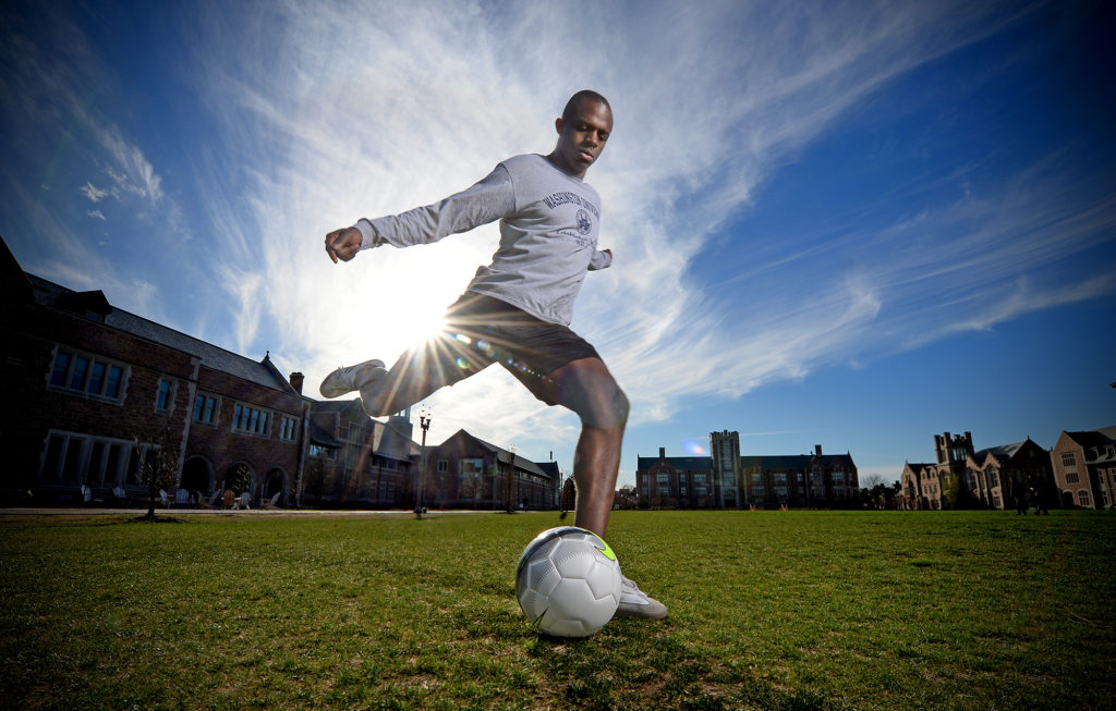 Ron Nwumeh prepares to kick a soccer ball on WashU's campus